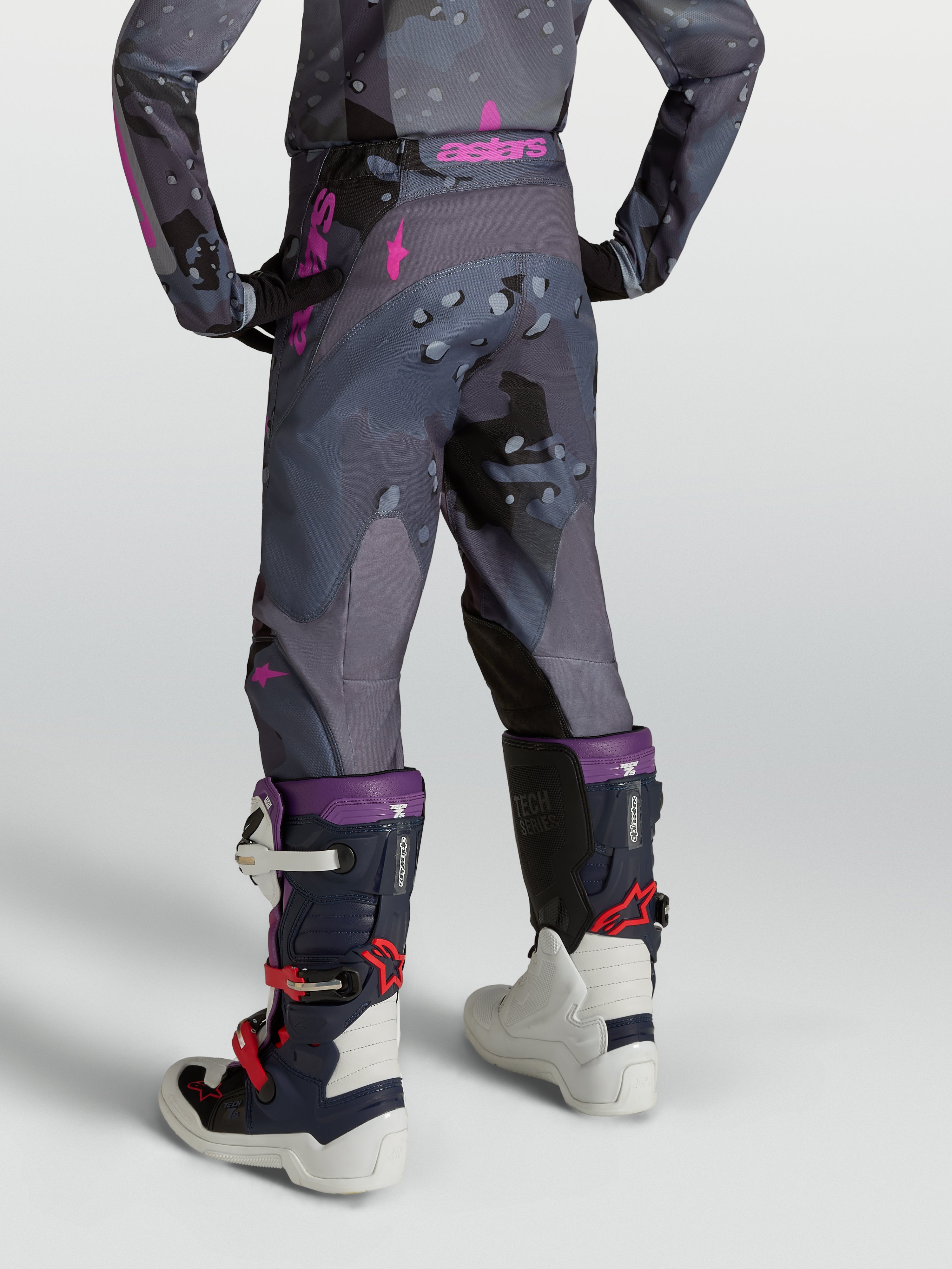 Spodnie Alpinestars Fluid Lone Młodzieżowe, spodnie motocrossowe, szary kamuflaż i fioletowy, krój 3D, widok z tyłu na modelu.