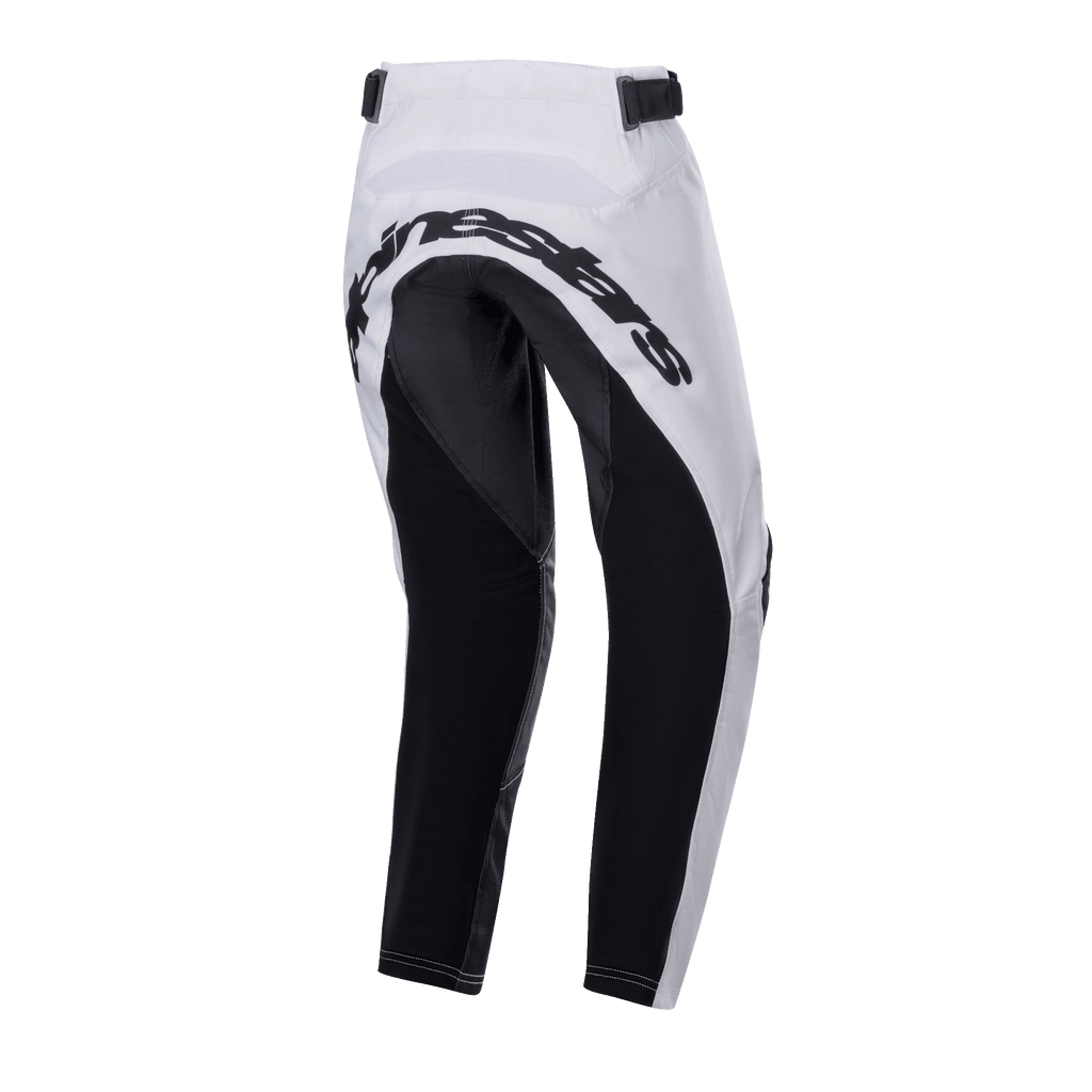 Alpinestars Youth Racer Lucent Pants 2024, młodzieżowe spodnie motocrossowe, biało-czarne, widok z tyłu ukazujący duże czarne wzmocnione panele na siedzeniu i wewnętrznej stronie nogawek, napis Alpinestars z tyłu oraz regulowane paski w talii do jazdy terenowej.