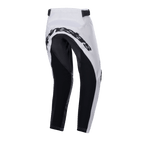 Alpinestars Youth Racer Lucent Pants 2024, młodzieżowe spodnie motocrossowe, biało-czarne, widok z tyłu ukazujący duże czarne wzmocnione panele na siedzeniu i wewnętrznej stronie nogawek, napis Alpinestars z tyłu oraz regulowane paski w talii do jazdy terenowej.