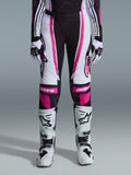 Alpinestars Stella Techstar Nomur 2026, damskie spodnie motocrossowe, czarno-białe z fuksją, noszone z dopasowaną koszulką wyścigową, rękawicami i białymi butami motocrossowymi, z wyrazistymi różowymi grafikami i logo astars na kolanach, zaprojektowane do profesjonalnej rywalizacji off-road.