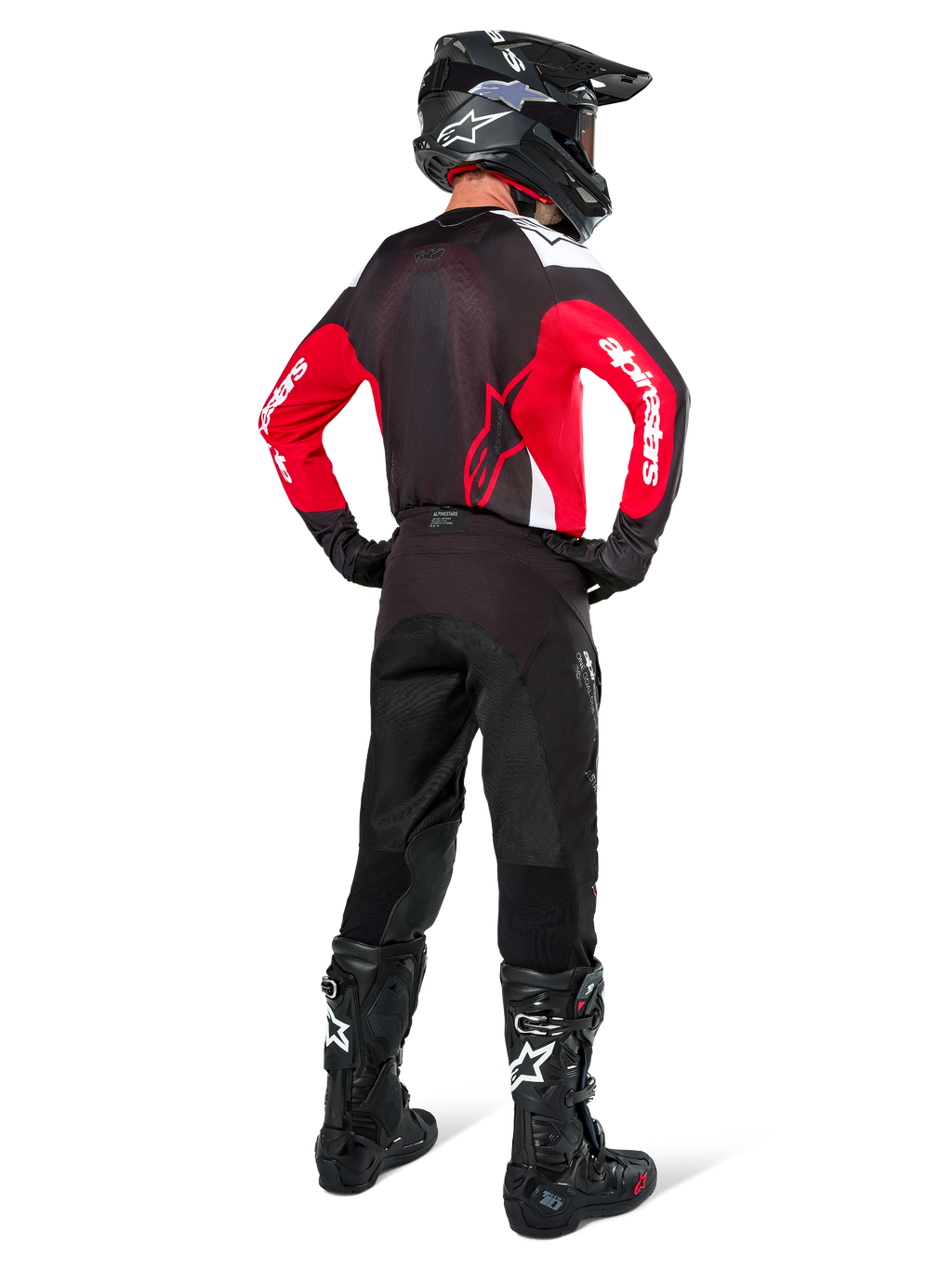 Motocross rider from behind wearing the Alpinestars Pro-Dura Jersey in Black, Bright Red, and White, paired with black motocross pants, helmet, and boots, showing the rear design and sleeve logos, coordinated off-road racing gear.