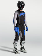 Alpinestars koszulka i zestaw Supertech Hiten AFD, czarno-niebieski komplet motocrossowy, białe buty wyścigowe.
