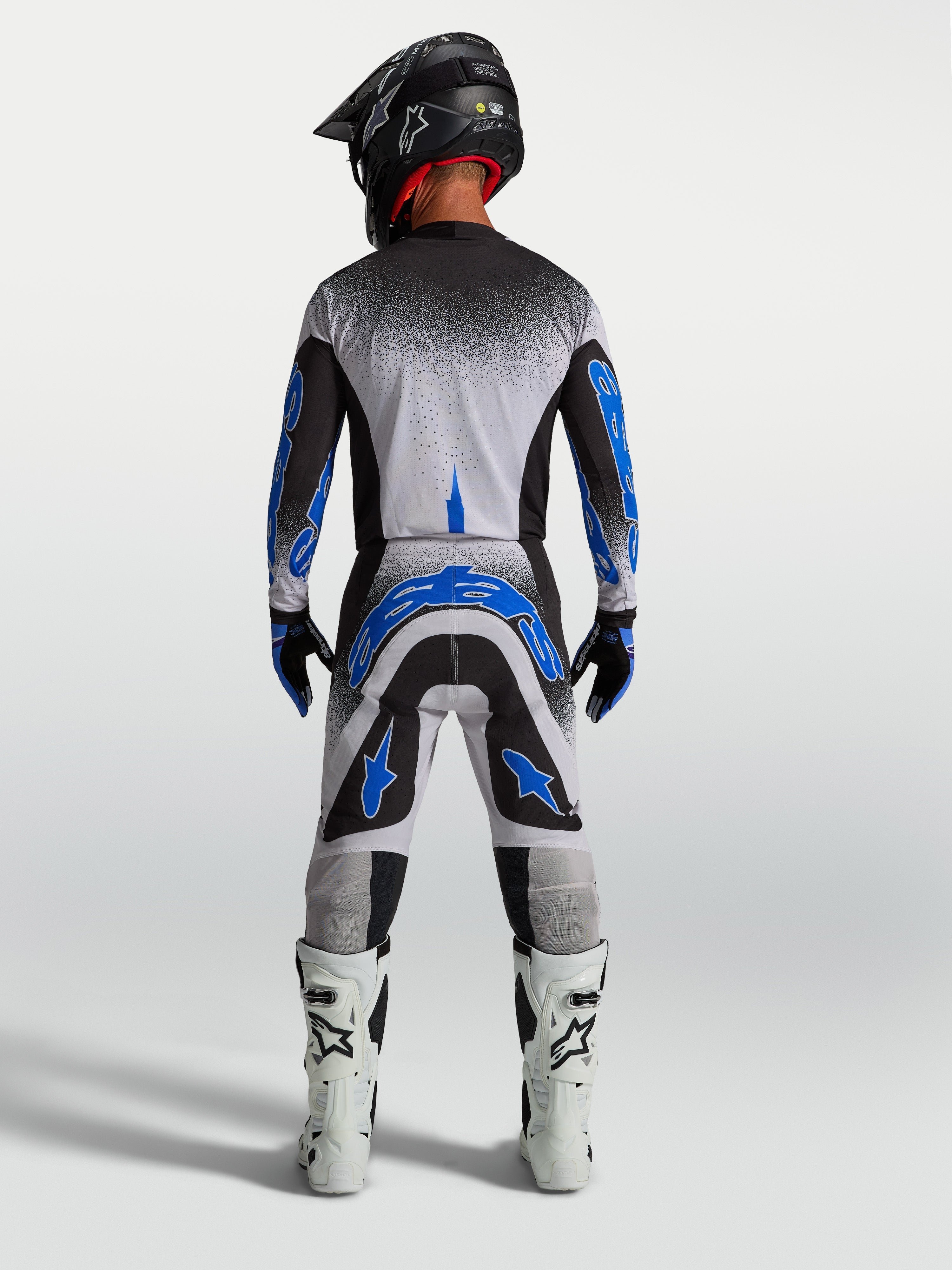 Koszulka i zestaw Alpinestars Supertech Hiten AFD, męski strój motocrossowy, czarny, biały i niebieski, widok od tyłu.