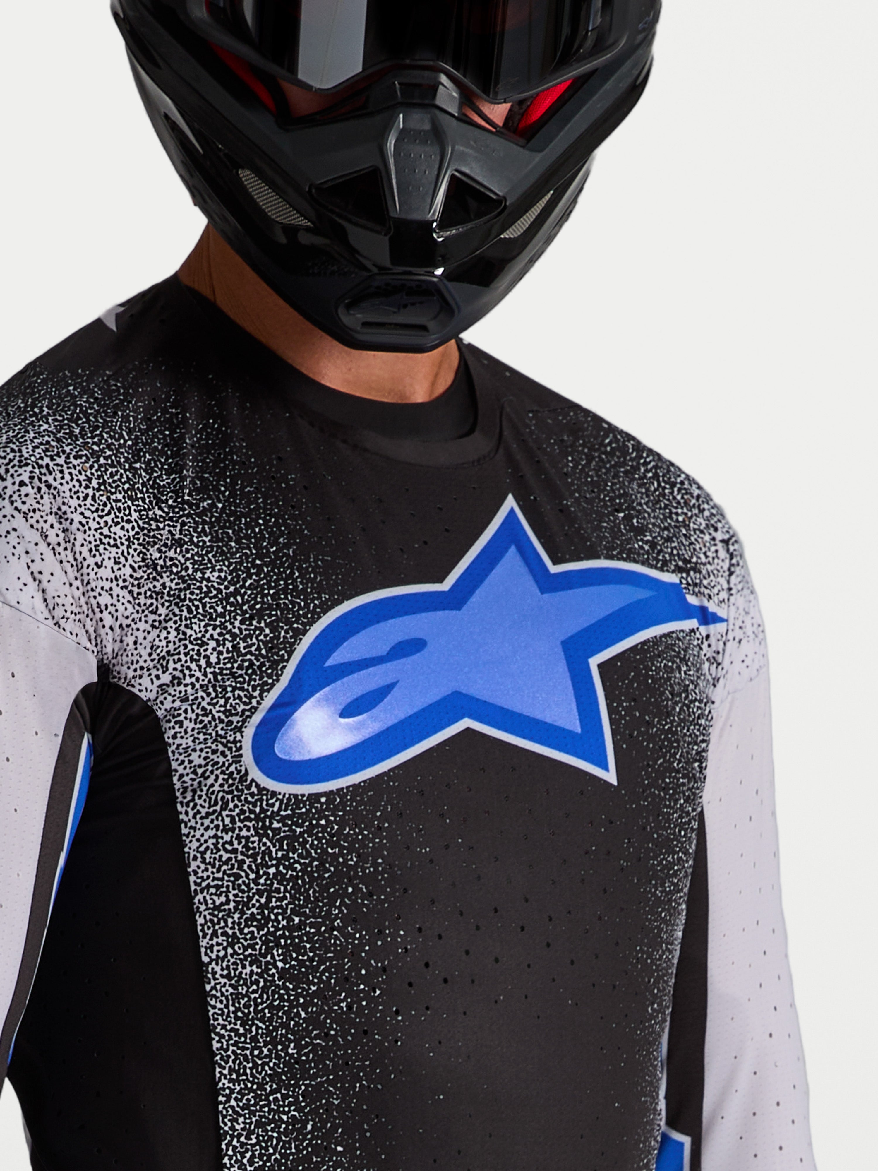 Alpinestars Supertech Hiten AFD, męska koszulka motocrossowa, czarna i niebieska, laserowo wycinane otwory wentylacyjne i duże niebieskie logo na piersi, profesjonalna odzież off-road