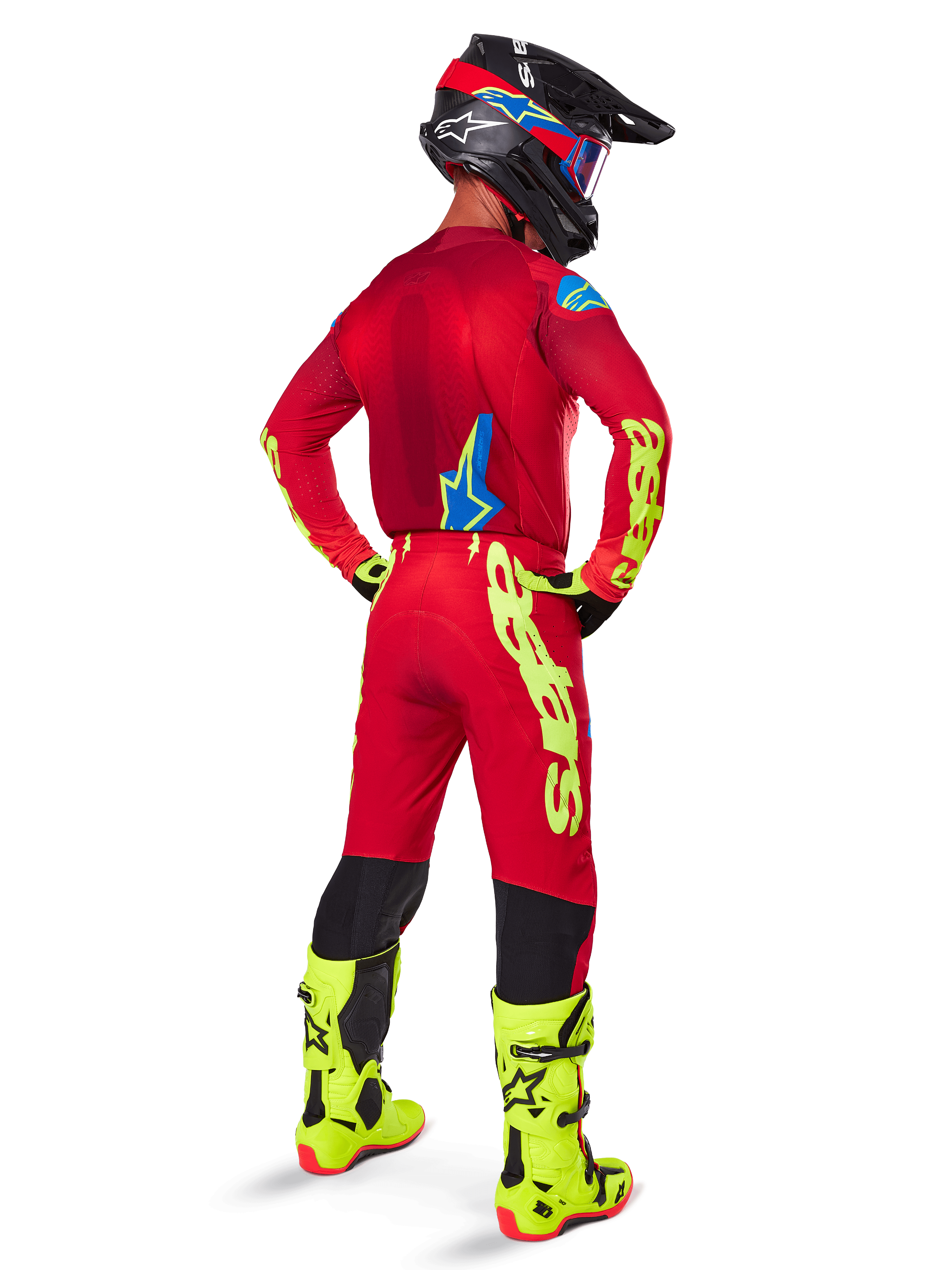 Motocross rider seen from the back wearing the Alpinestars 2025 Supertech Maker Jersey, Bright Red and Yellow Fluo, matching pants with yellow branding, yellow fluo boots, and a black and red helmet, coordinated outfit for pro-level off-road racing