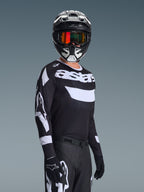 Motocyklista motocrossowy w koszulce 2026 Racer Air Riway, czarno-biała koszulka z logo „astars”, dopasowany czarno-biały kask z pomarańczowymi lustrzanymi goglami, czarne spodnie i rękawice motocrossowe, skoordynowany strój do wyścigów off-road
