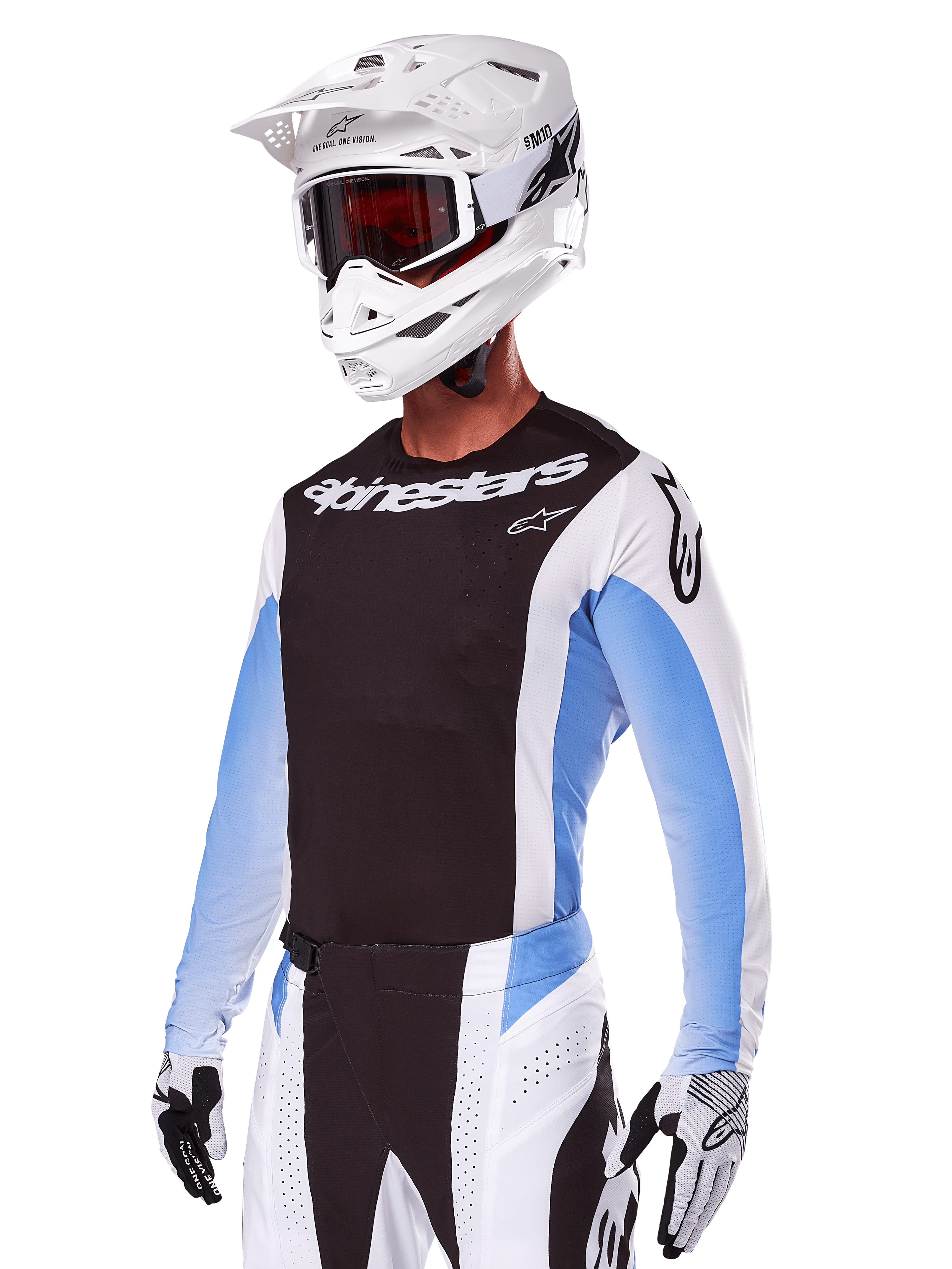 Motocyklista motocrossowy w zestawie Alpinestars 2025 Techstar Melt, biały z czarnymi i jasnoniebieskimi akcentami, koszulka z czarnym przodem i białymi rękawami, pasujące biało-czarne spodnie, biały kask SM10 z goglami i czarno-białe rękawice, kompletny profesjonalny strój wyścigowy off-road.