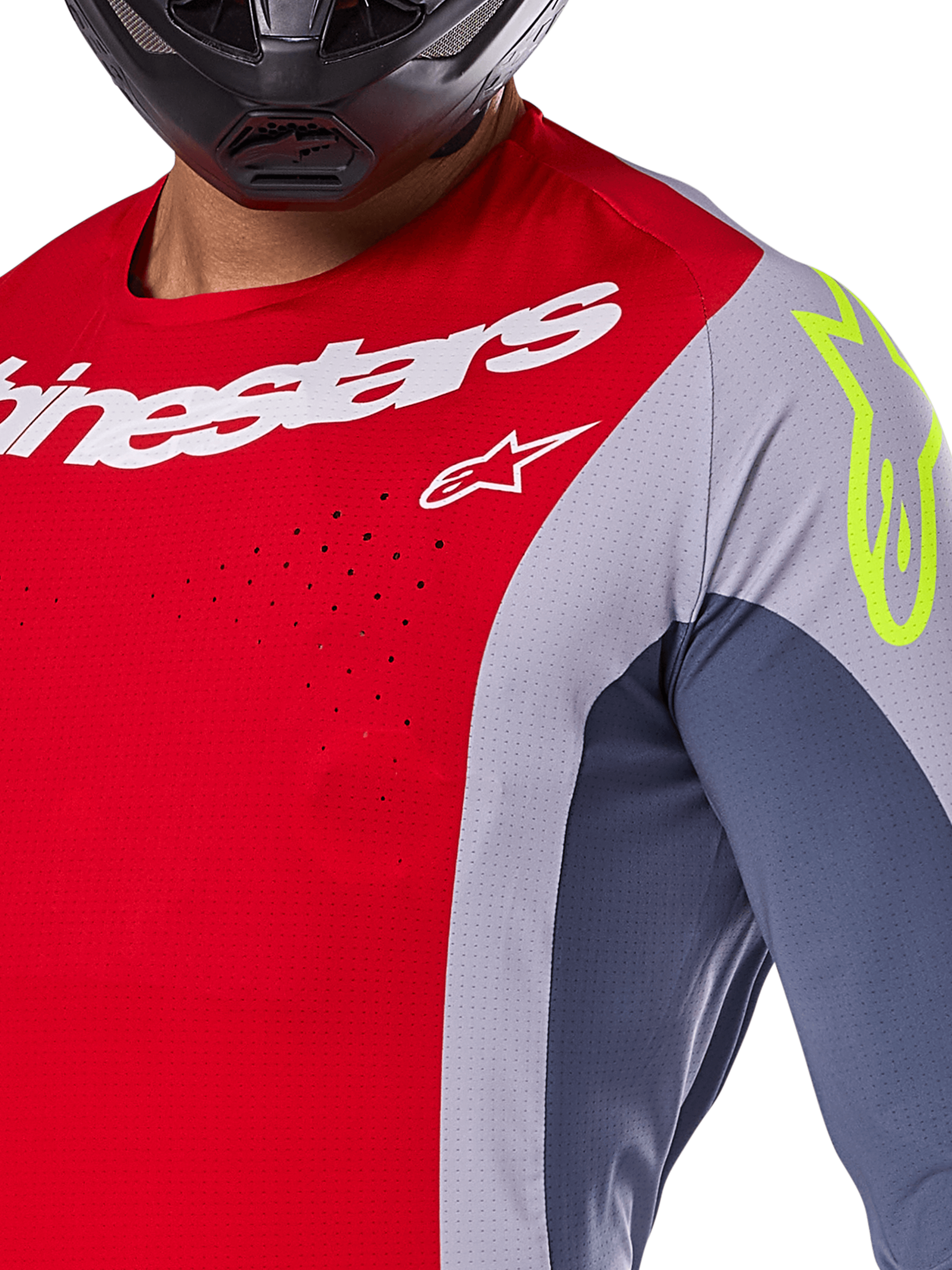 Koszulka Alpinestars Techstar Melt 2025, koszulka motocrossowa, jasnoczerwona i szara z ciemnoniebieskimi panelami, białe logo Alpinestars i neonowożółte logo na ramieniu, zbliżenie na laserowo wycinane otwory wentylacyjne, czarny kask