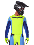 Koszulka Techstar Melt 2025, koszulka motocrossowa, żółta fluo i niebieska, z laserowo wycinaną wentylacją i sportowym krojem wyścigowym, zawodnik w czarnym kasku i żółtych rękawicach fluo