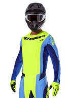 Alpinestars 2025 Techstar Melt Gear Set, zawodnik motocrossowy w jaskrawożółtej i niebieskiej koszulce oraz pasujących spodniach, czarny kask z biało-czarnymi goglami, żółte rękawice, dopasowany strój do wyścigów terenowych z wyraźnym brandingiem Alpinestars i perforowanymi detalami