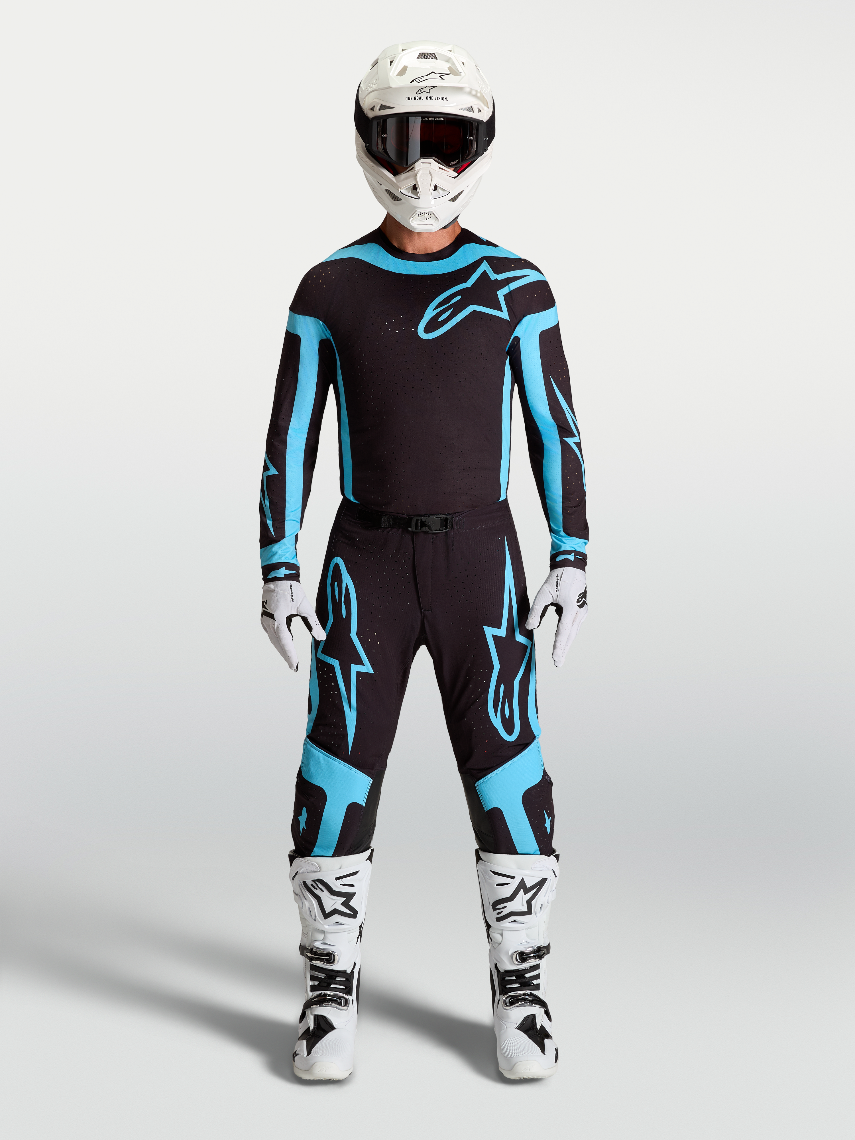 Alpinestars Supertech Vesta Jersey and Gear Set, Men's Motocross Outfit, Black and Turquoise with White Boots and Helmet.