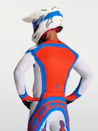 Koszulka Alpinestars Supertech Vesta, męska koszulka motocrossowa, czerwona, niebieska i biała, oddychające perforacje laserowe, widok z tyłu.