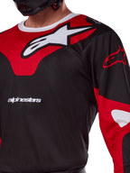 Alpinestars 2025 Racer Veil Jersey, koszulka motocrossowa, czarno-czerwona, zbliżenie na duże białe logo gwiazdy na czerwonym panelu piersiowym i logotyp „alpinestars”, sportowy design z oddychającego materiału technicznego do wyścigów terenowych