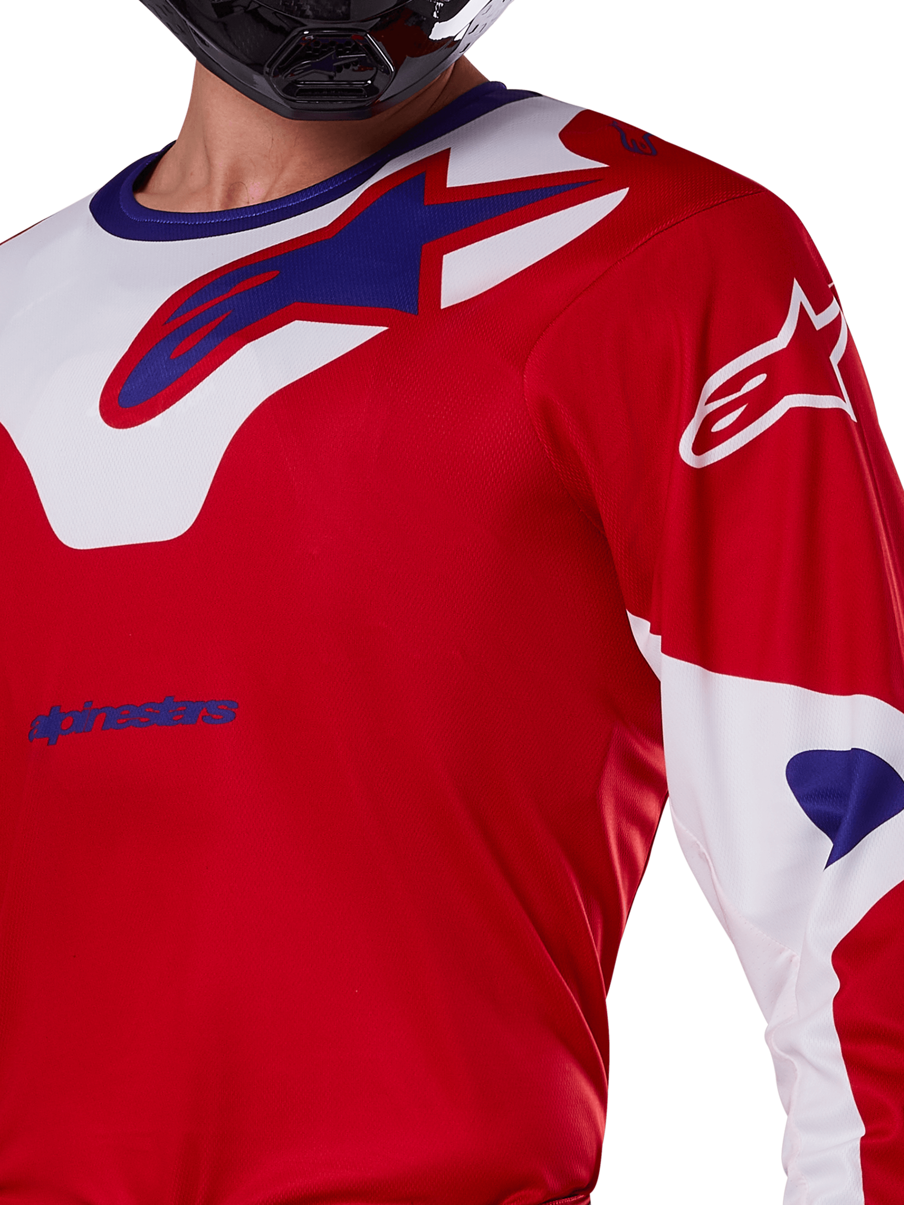 Alpinestars 2025 Racer Veil Jersey, koszulka motocrossowa, jaskrawoczerwona i biała, zbliżenie na klatkę piersiową i górną część tułowia, niebieskie logo Alpinestars na białym panelu kołnierza, czerwone rękawy z białymi akcentami, noszona z czarnym kaskiem, techniczna odzież do jazdy terenowej