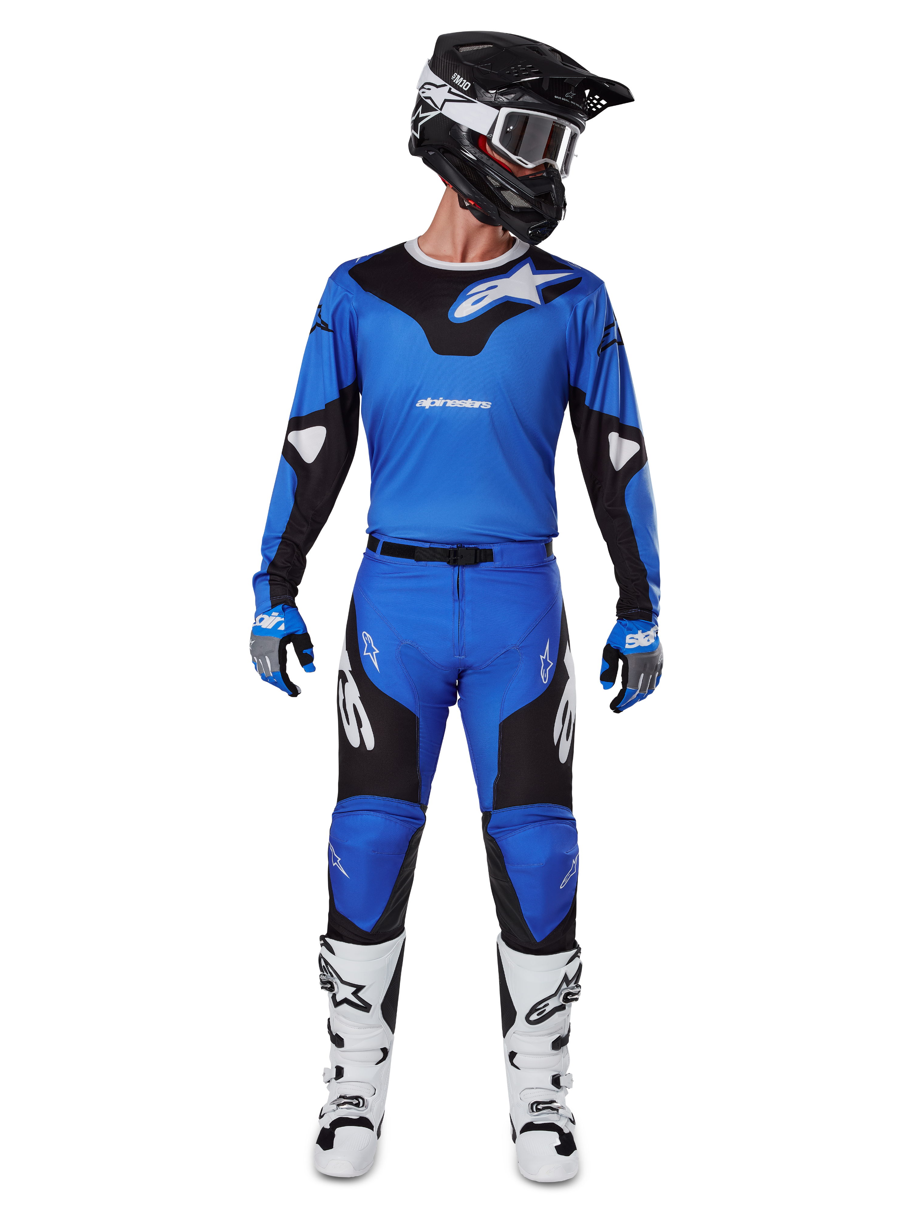 Motocyklista motocrossowy w zestawie Alpinestars 2025 Racer Veil, niebiesko-czarna koszulka i dopasowane spodnie, czarny kask z białymi goglami, biało-czarne buty, skoordynowany strój wyścigowy do jazdy terenowej motocross.