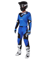 Alpinestars Racer Veil Gear Set 2025, niebiesko-czarna koszulka i spodnie motocrossowe, kompletny strój wyścigowy MX z czarnym kaskiem, białymi goglami i białymi butami, techniczna odzież off-road