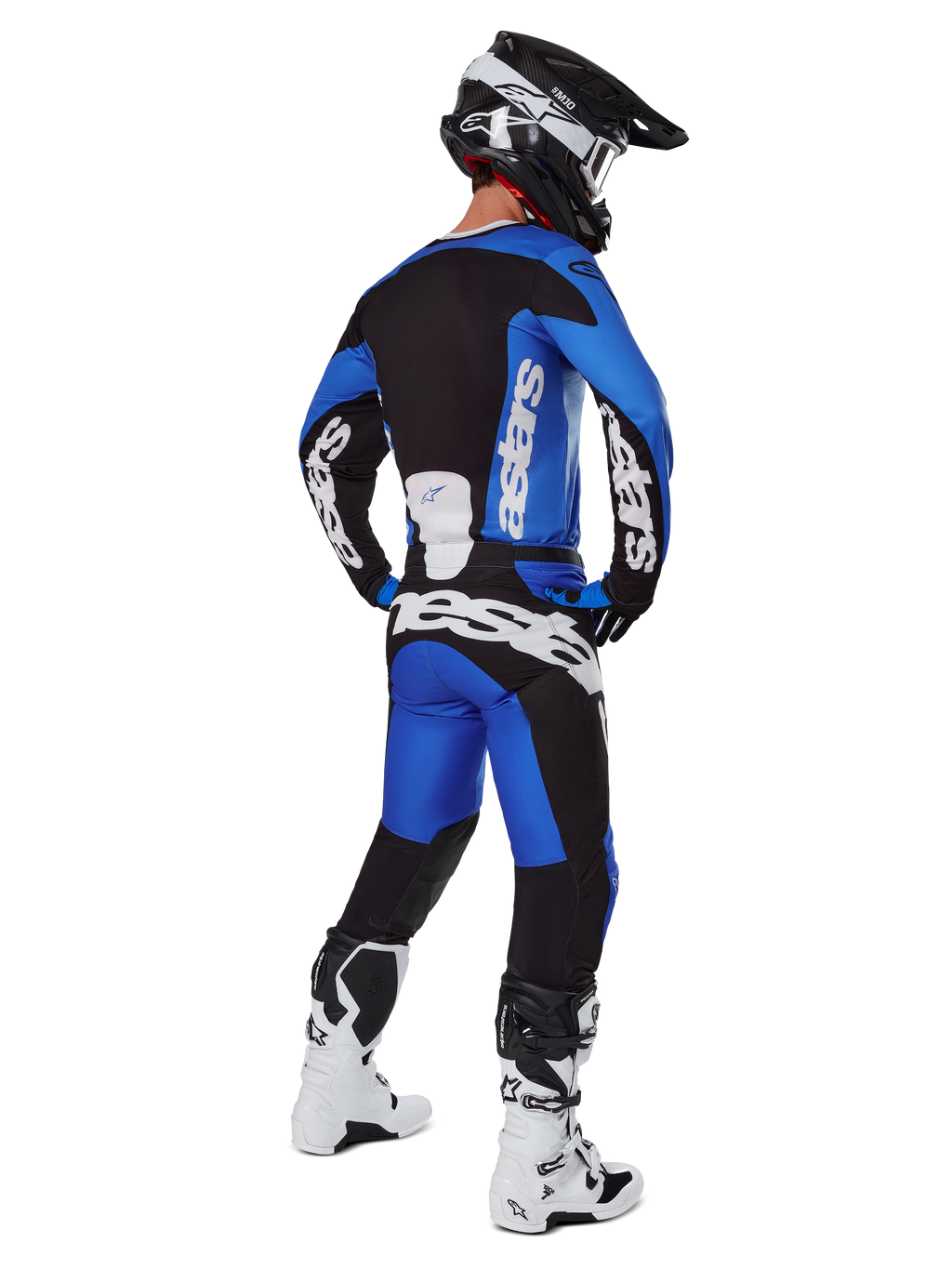 Motocyklista motocrossowy w pełnym stroju wyścigowym widziany od tyłu, koszulka Racer Veil 2025 i pasujące spodnie w kolorze niebieskim i czarnym, z białym brandingiem Alpinestars, czarny kask, biało-czarne buty, skoordynowany zestaw do wyścigów terenowych