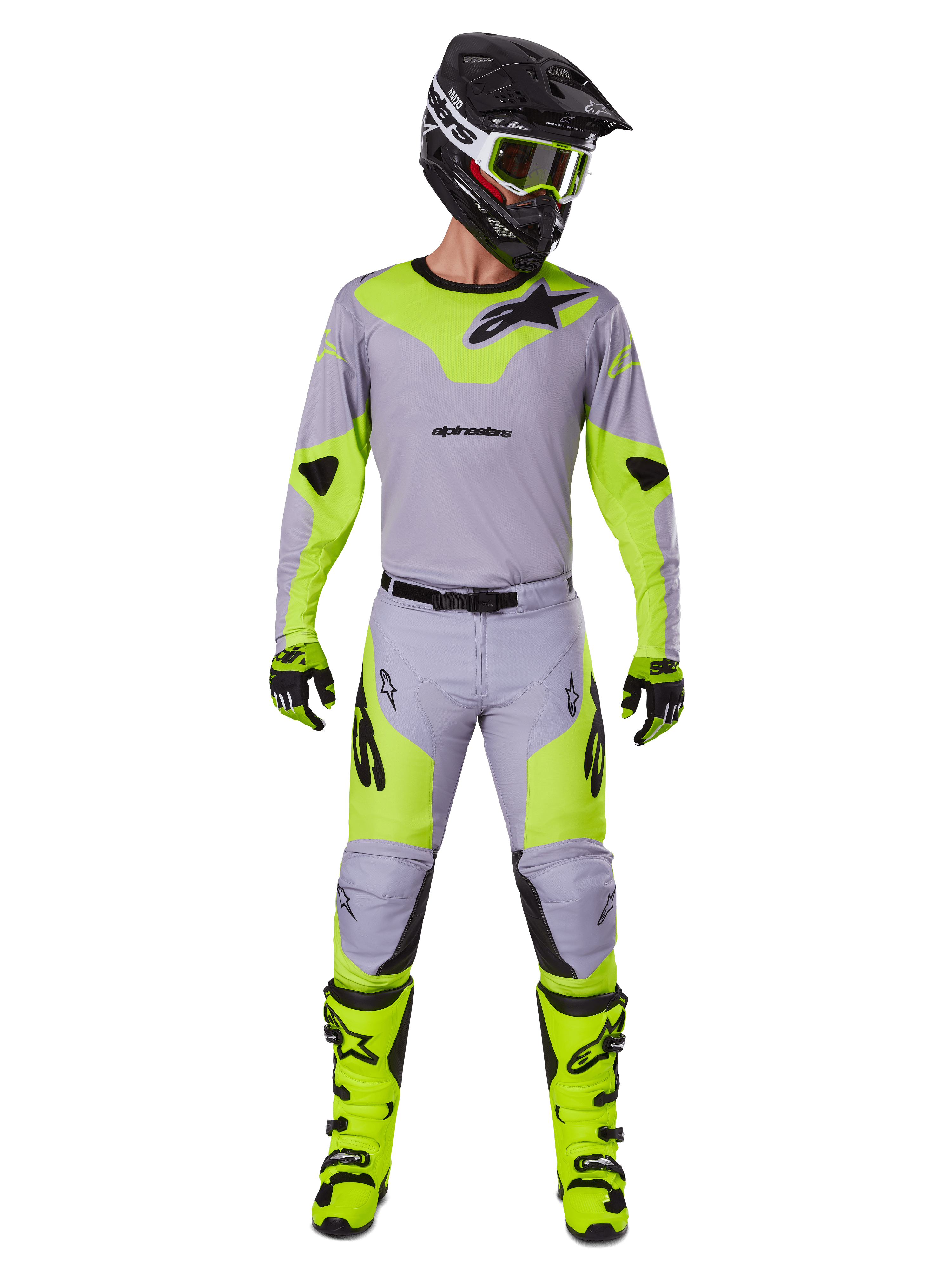 Zawodnik motocrossowy w zestawie Alpinestars Racer Veil 2025 w kolorze szarym i żółtym neonowym, lekka koszulka i dopasowane spodnie, czarny kask, gogle fluo, rękawice i jaskrawożółte buty, kompletny profesjonalny strój off-road