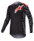 Alpinestars 2023 Supertech North Jersey, koszulka motocrossowa, czarna z neonowymi czerwonymi akcentami, długie rękawy z wzorem białych kropek, czerwono-białe logo z gwiazdą na piersi i ramionach, lekka siatka techniczna o sportowym kroju wyścigowym