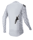 Alpinestars 2023 Supertech North Jersey, koszulka motocrossowa, kolor Haze Gray i czarny, widok z tyłu z abstrakcyjnym nakrapianym wzorem na rękawach i bokach, duże logo z gwiazdą, przedłużony tylny panel i oddychająca konstrukcja techniczna