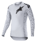 Alpinestars Supertech North Jersey 2023, koszulka motocrossowa, kolor Haze Gray i czarny, biała koszulka z długim rękawem z szarym nakrapianym wzorem na rękawach i bokach, czarne logo z gwiazdą na piersi i ramionach, elastyczna siateczka z zaokrąglonym dołem