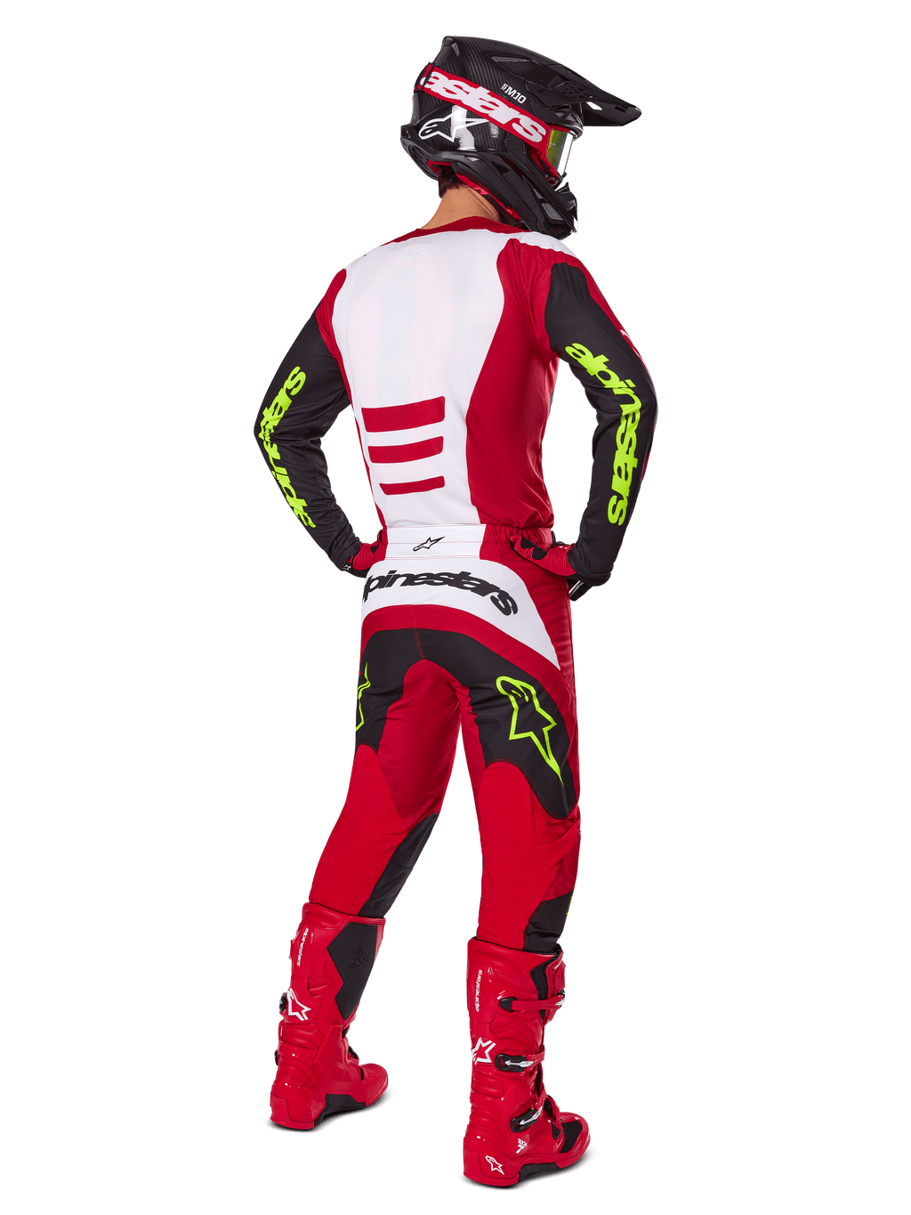 Motocyklista motocrossowy od tyłu w zestawie Alpinestars 2025 Fluid Haul, jaskrawoczerwony i czarny z białymi panelami, neonowożółte logo na rękawach i spodniach, dopasowane czerwone buty i czarny kask, kompletny profesjonalny strój do jazdy terenowej