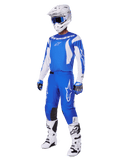 Zawodnik motocrossowy w kompletnym zestawie 2025 Fluid Haul, niebiesko-biała koszulka i spodnie z logo Alpinestars, biały kask z niebieskimi goglami, białe buty i niebieskie rękawice, dopasowany strój wyścigowy do jazdy terenowej.