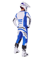 Jeździec motocrossowy widziany od tyłu w zestawie Alpinestars 2025 Fluid Haul, niebiesko-biała koszulka i pasujące spodnie, biały kask z niebieskimi akcentami oraz biało-czarne buty wyścigowe, dopasowany strój do jazdy terenowej