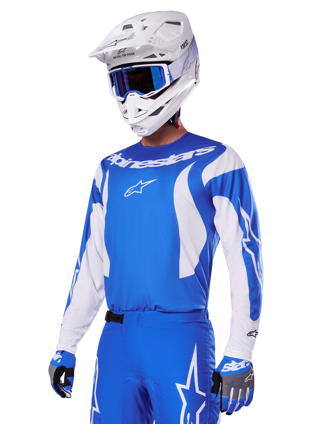 Zawodnik motocrossowy w zestawie Alpinestars 2025 Fluid Haul w kolorze niebiesko-białym, niebieska koszulka z białymi akcentami, pasujące niebieskie spodnie z logo gwiazdy, biały kask z niebieskimi goglami i dopasowane niebiesko-szare rękawice, kompletny strój wyścigowy off-road