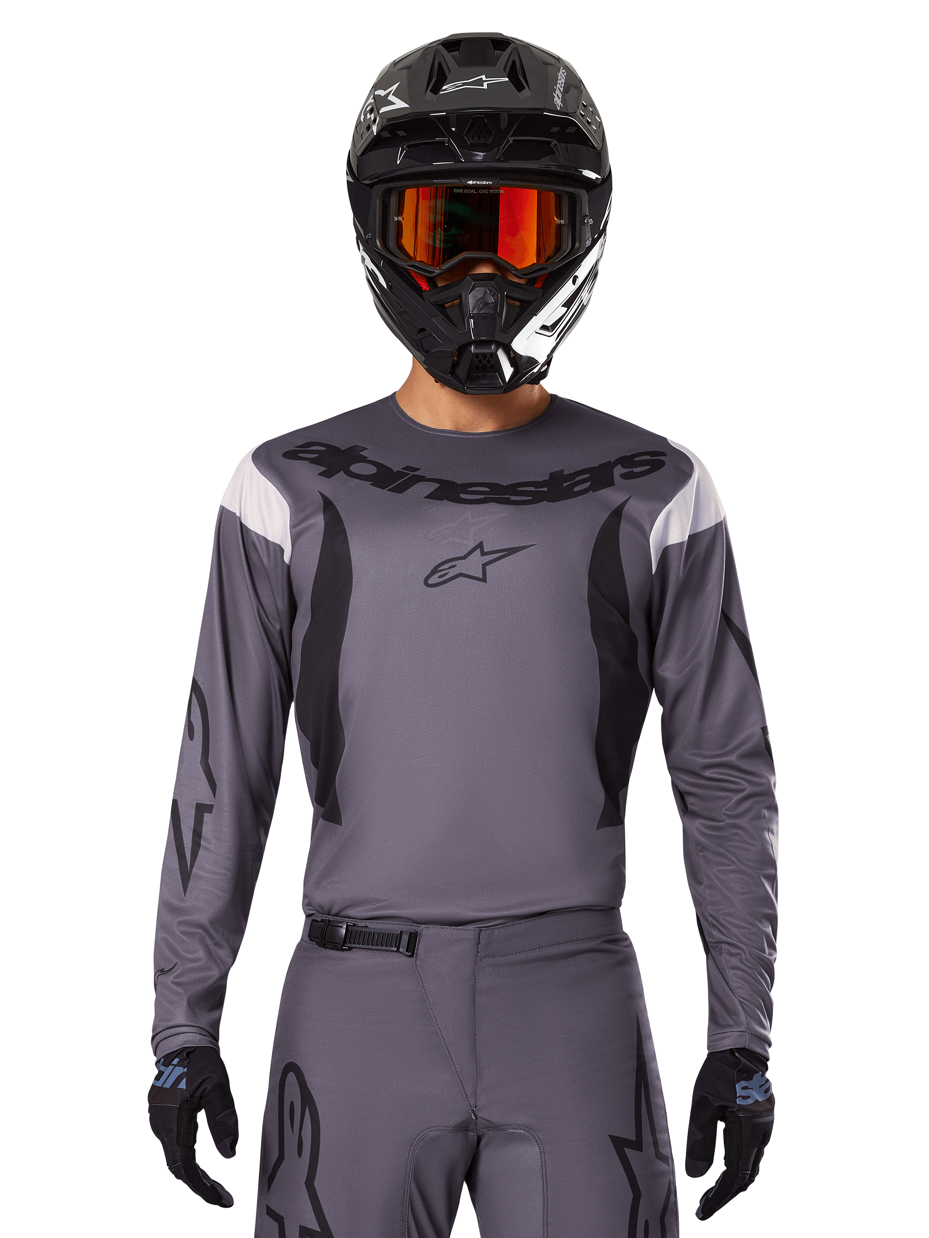 Kierowca motocrossowy w koszulce i zestawie odzieży 2025 Fluid Haul, szary z czarnymi i białymi akcentami, z długimi rękawami i wyraźnym logo, czarny kask z pomarańczowymi goglami i czarne rękawice, dopasowany strój do wyścigów terenowych
