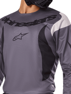 Alpinestars 2025 Fluid Haul Jersey, koszulka motocrossowa, szara z czarnymi i białymi akcentami, z logo i logotypem Alpinestars na piersi, sportowy krój do jazdy terenowej