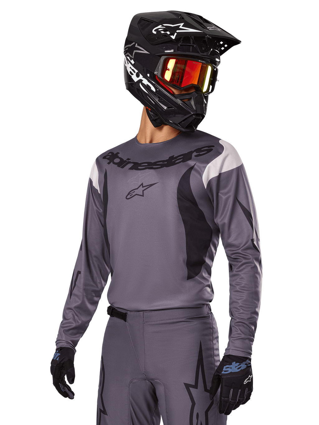 Zestaw Alpinestars 2025 Fluid Haul, szara koszulka i spodnie motocrossowe z czarnymi i białymi akcentami, noszony z czarnym kaskiem, czerwonymi goglami i czarnymi rękawicami, sportowy krój do jazdy off-road