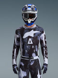 Alpinestars 2026 Racer Lahnd Jersey, bluza motocrossowa, wzór Iron Camo w kolorystyce czarno-białej, z wyraźnym logo gwiazdy i napisem ASTARS, noszona z pasującymi spodniami i niebieskim kaskiem motocrossowym