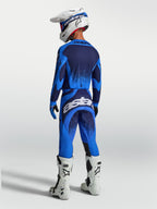 Alpinestars Techstar Swan, męski zestaw odzieży MX, niebieski i ciemnoniebieski, biały kask i buty, widok z tyłu.