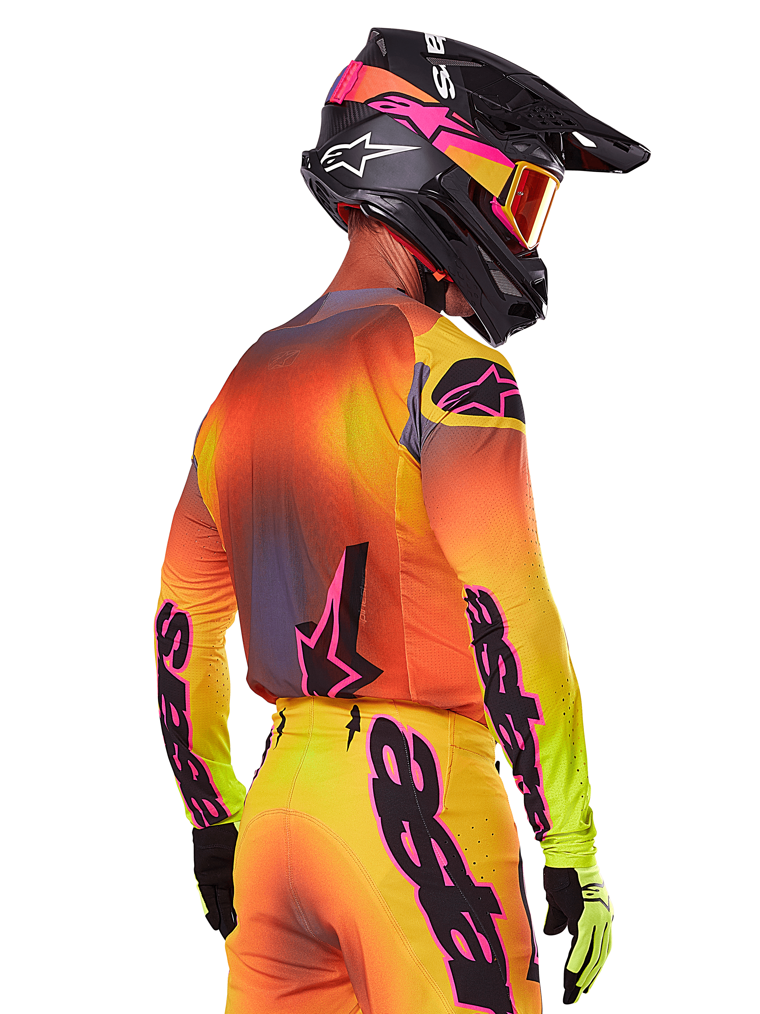 Motocyklista motocrossowy widziany z boku i z tyłu w zestawie Alpinestars 2025 Supertech Lipan, gradient żółto-pomarańczowo-czerwony z czarnym i różowym logo, czarny kask z różowymi akcentami i pomarańczowe gogle, profesjonalny strój wyścigowy off-road