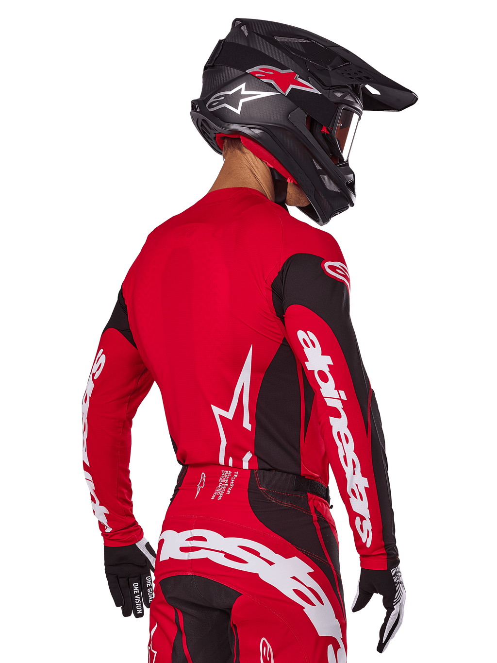 Zawodnik motocrossowy widziany z tyłu w zestawie Alpinestars 2025 Techstar Dreem, czerwono-czarna koszulka z białym brandingiem na rękawach, pasujące czerwono-czarne spodnie z wyraźnym białym logo na siedzeniu, czarny karbonowy kask z czerwonymi akcentami, czarno-białe rękawice, profesjonalny strój do wyścigów terenowych