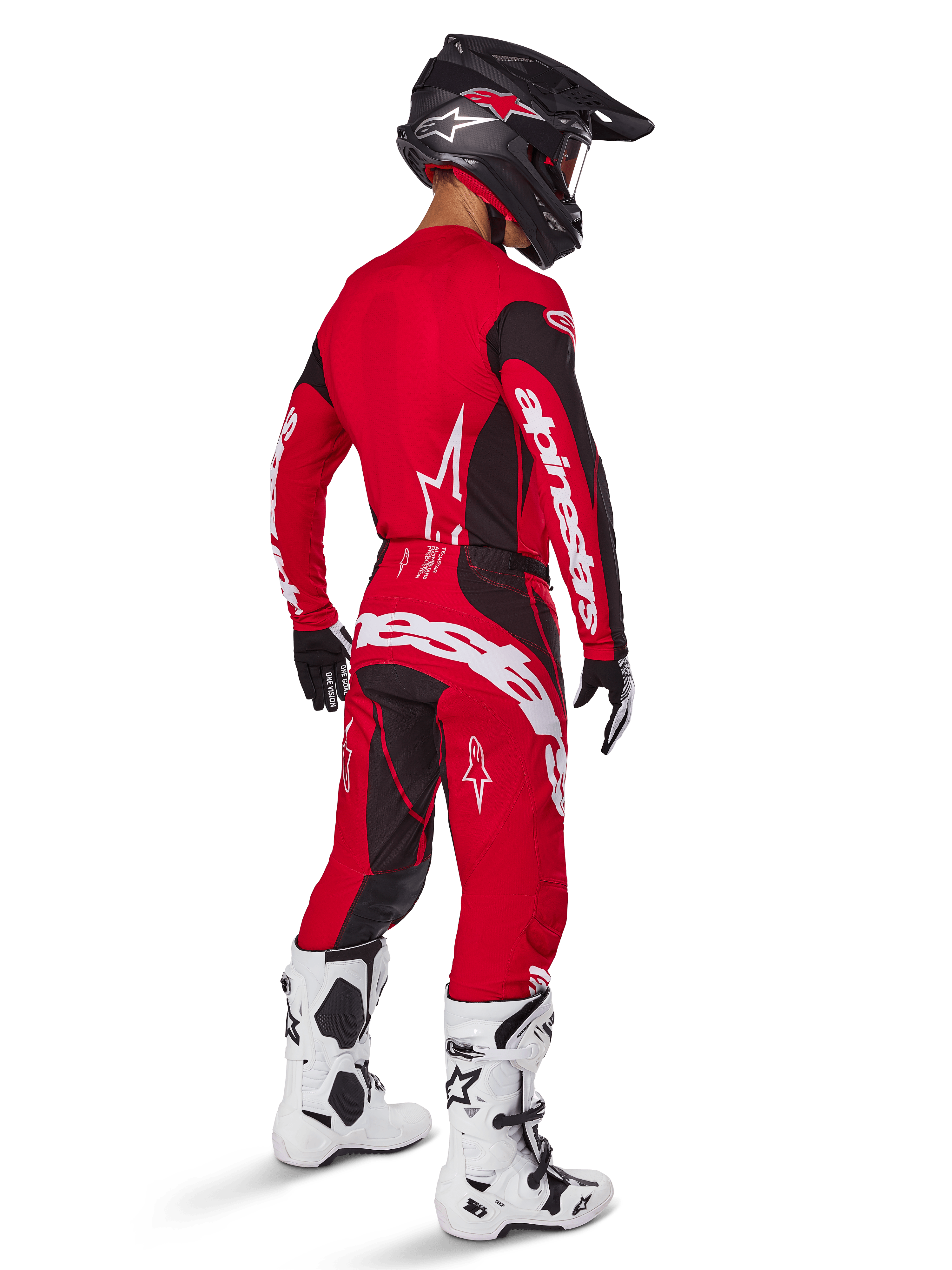 Motocyklista motocrossowy ubrany w zestaw Alpinestars 2025 Techstar Dreem w kolorze jaskrawoczerwonym i czarnym, z białym logo na koszulce i spodniach, w czarnym kasku, biało-czarnych butach i czarno-białych rękawicach, widok z tyłu pod kątem trzech czwartych.