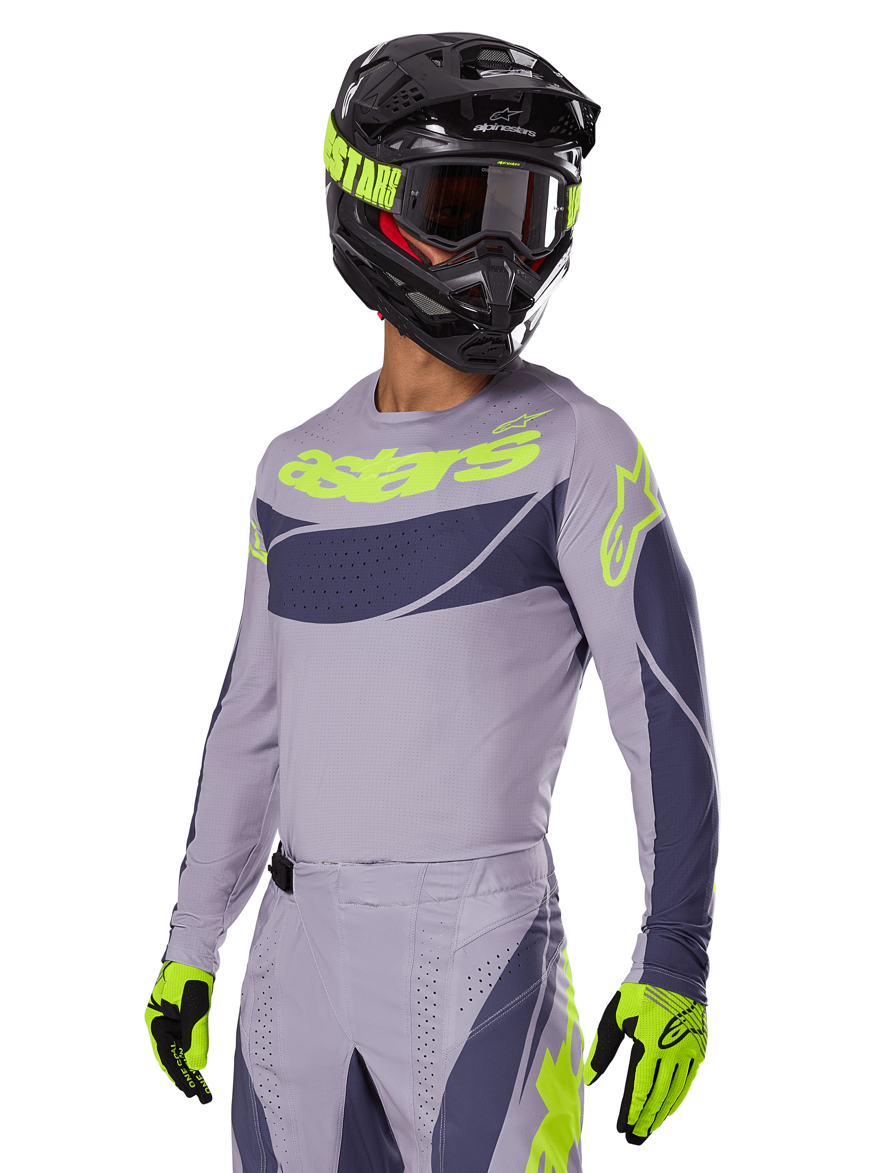 Motocyklista motocrossowy w koszulce Alpinestars 2025 Techstar Dreem, szary i ciemnoszary z limonkowymi logo, pasujące spodnie, czarny kask z limonkowymi akcentami, limonkowo-czarne rękawice, skoordynowany strój do wyścigów terenowych