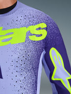 Alpinestars 2026 Supertech Scenz Jersey, koszulka motocrossowa, fioletowa i żółta neonowa, zbliżenie na perforowany, elastyczny materiał siatkowy oraz jaskrawożółte logo Alpinestars na klatce piersiowej i rękawie