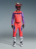 Zestaw odzieży Supertech Scenz 2026, strój motocrossowy Alpinestars, intensywny czerwono-pomarańczowy i fioletowy, koszulka z czarnym brandingiem „astars”, pasujące spodnie z fioletowymi logotypami gwiazd, kolorowy kask wyścigowy i białe buty, profesjonalny zestaw wyczynowy off-road