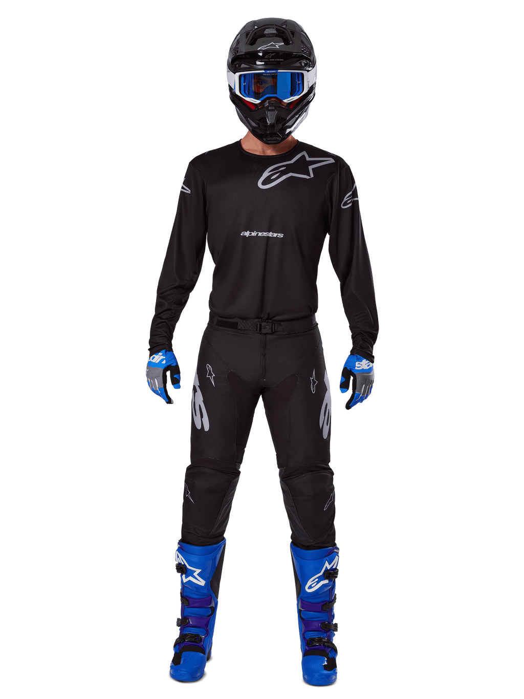 Zestaw Alpinestars 2025 Racer Graphite, motocyklista motocrossowy w pełnym stroju wyścigowym, czarna koszulka z długim rękawem i szarymi logotypami Alpinestars, czarne spodnie, czarny kask z niebieskimi goglami, niebiesko-szare rękawice, niebiesko-czarne buty, dopasowany komplet do wyścigów motocrossowych