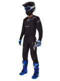 Zestaw odzieży Racer Graphite 2025, kompletny strój motocrossowy, czarno-szara koszulka i spodnie ze srebrnym logo, czarny kask z goglami o niebieskich szybkach, niebiesko-czarne rękawice, jaskrawoniebieskie buty, profesjonalny sprzęt do jazdy terenowej