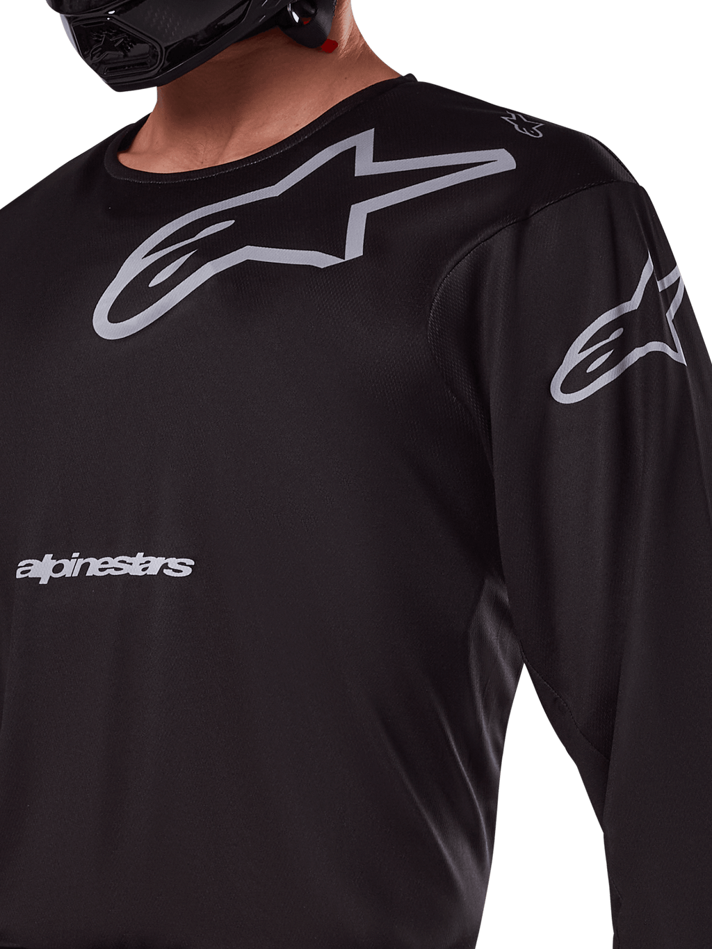 Alpinestars 2025 Racer Graphite Jersey, czarno-szara, zbliżenie na motocyklistę w koszulce motocrossowej, szare logo Alpinestars i gwiazdy A-star, techniczny materiał poliestrowy do jazdy terenowej