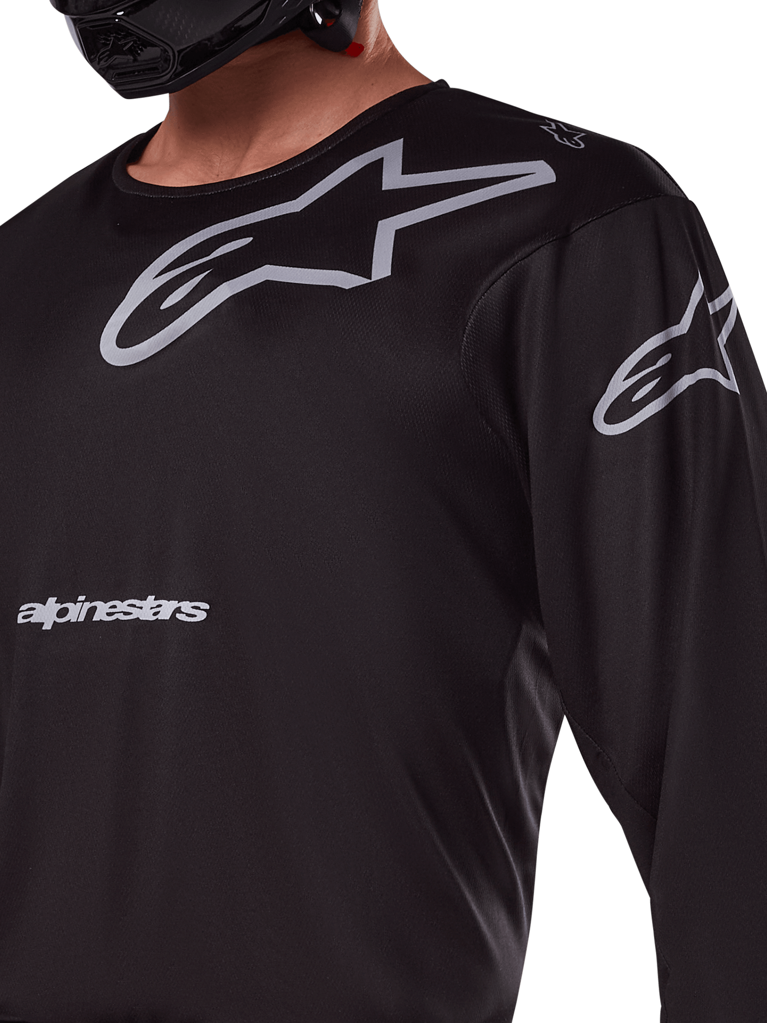Alpinestars 2025 Racer Graphite Jersey, czarno-szara, zbliżenie na motocyklistę w koszulce motocrossowej, szare logo Alpinestars i gwiazdy A-star, techniczny materiał poliestrowy do jazdy terenowej