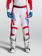 Alpinestars Spodnie Racer Hunt, spodnie motocrossowe męskie, białe i czerwone z niebieskimi detalami, ergonomiczna konstrukcja z panelami skórzanymi na kolanach, wersja on-model