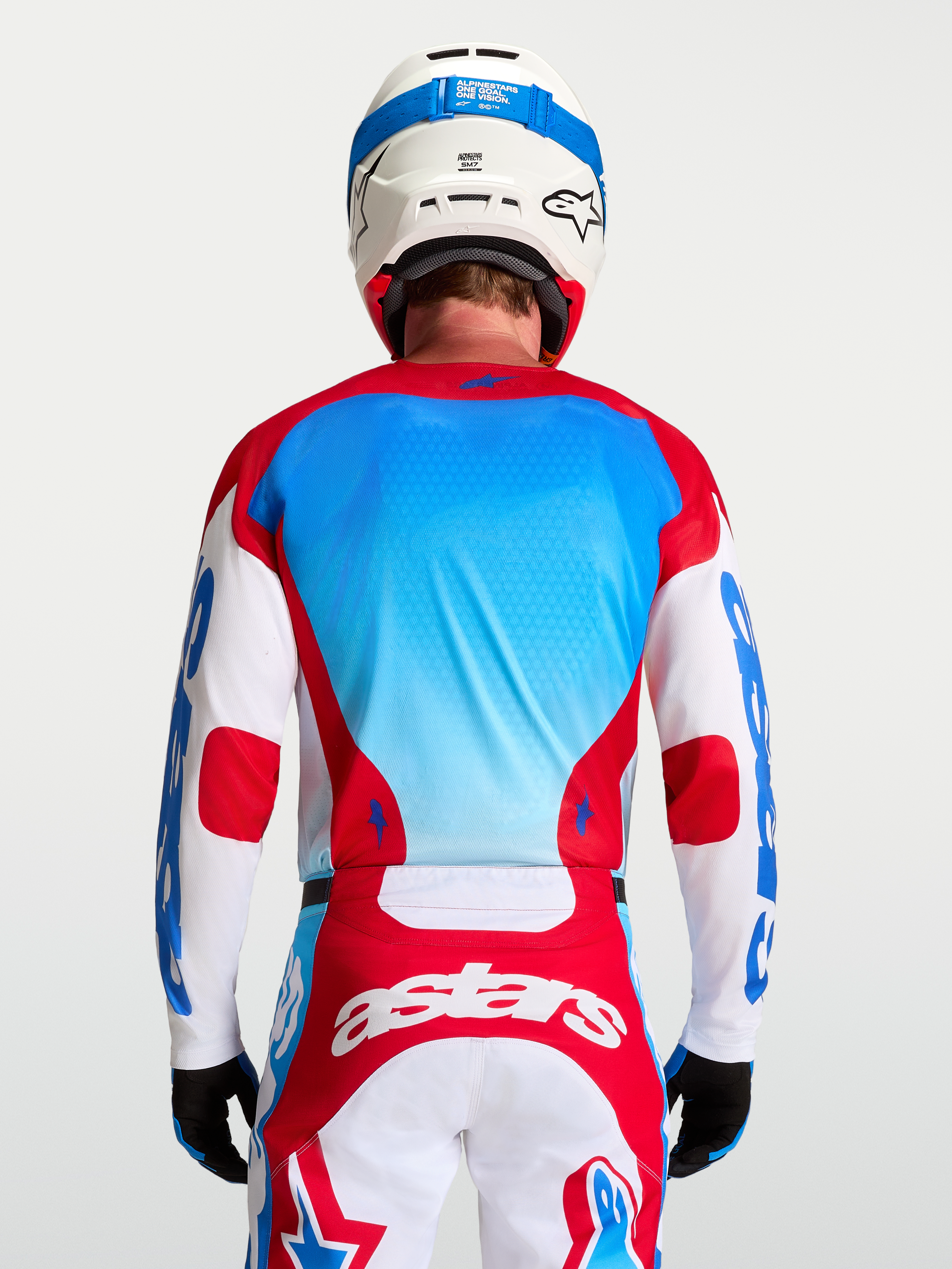 Koszulka Racer Hunt Alpinestars, męska koszulka motocrossowa, czerwona i niebieska, oddychająca, widok z tyłu na modelu.