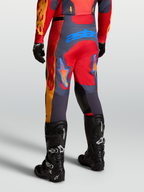 Alpinestars Spodnie Racer Hunt, męskie spodnie motocrossowe, czerwone i szare, widok od tyłu w pozycji sportowej.
