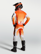 Koszulka Alpinestars Racer Amber, pomarańczowo-biała, widok z tyłu, materiał odprowadzający wilgoć, krój race fit do motocrossu.