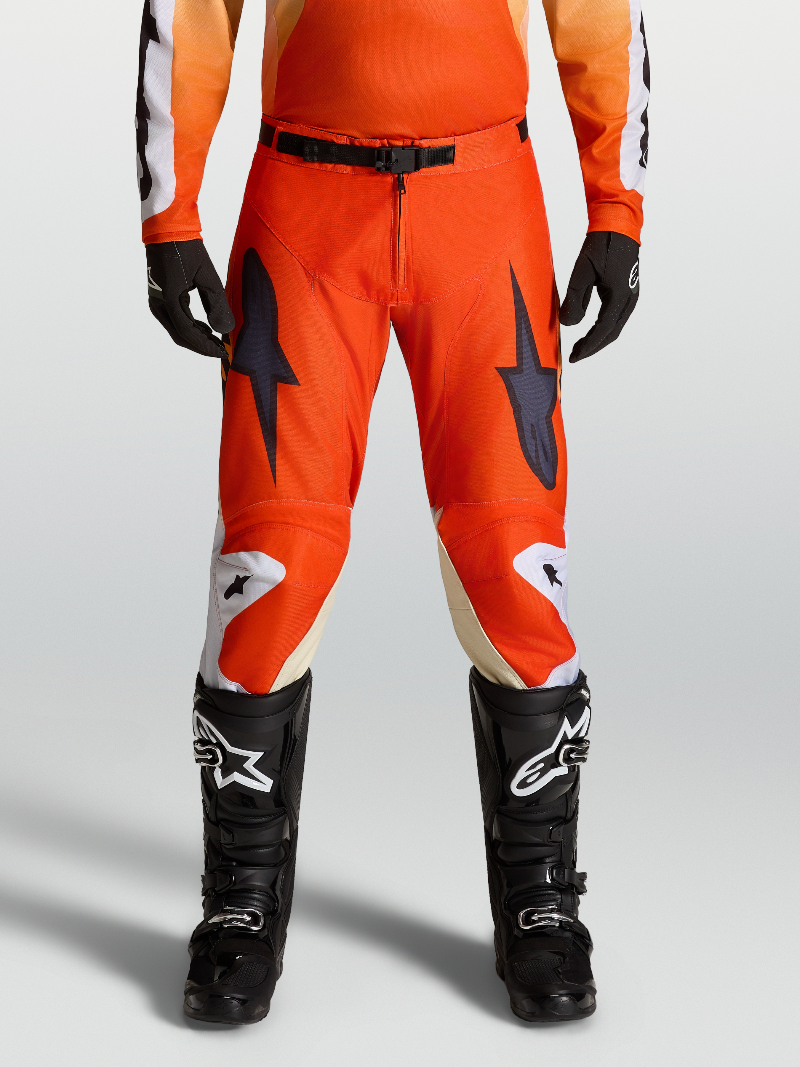 Alpinestars Spodnie Racer Amber 2027, czerwone spodnie motocrossowe, widok na modelu, trwała tkanina poliestrowa 600D i wstępnie zakrzywiony krój.