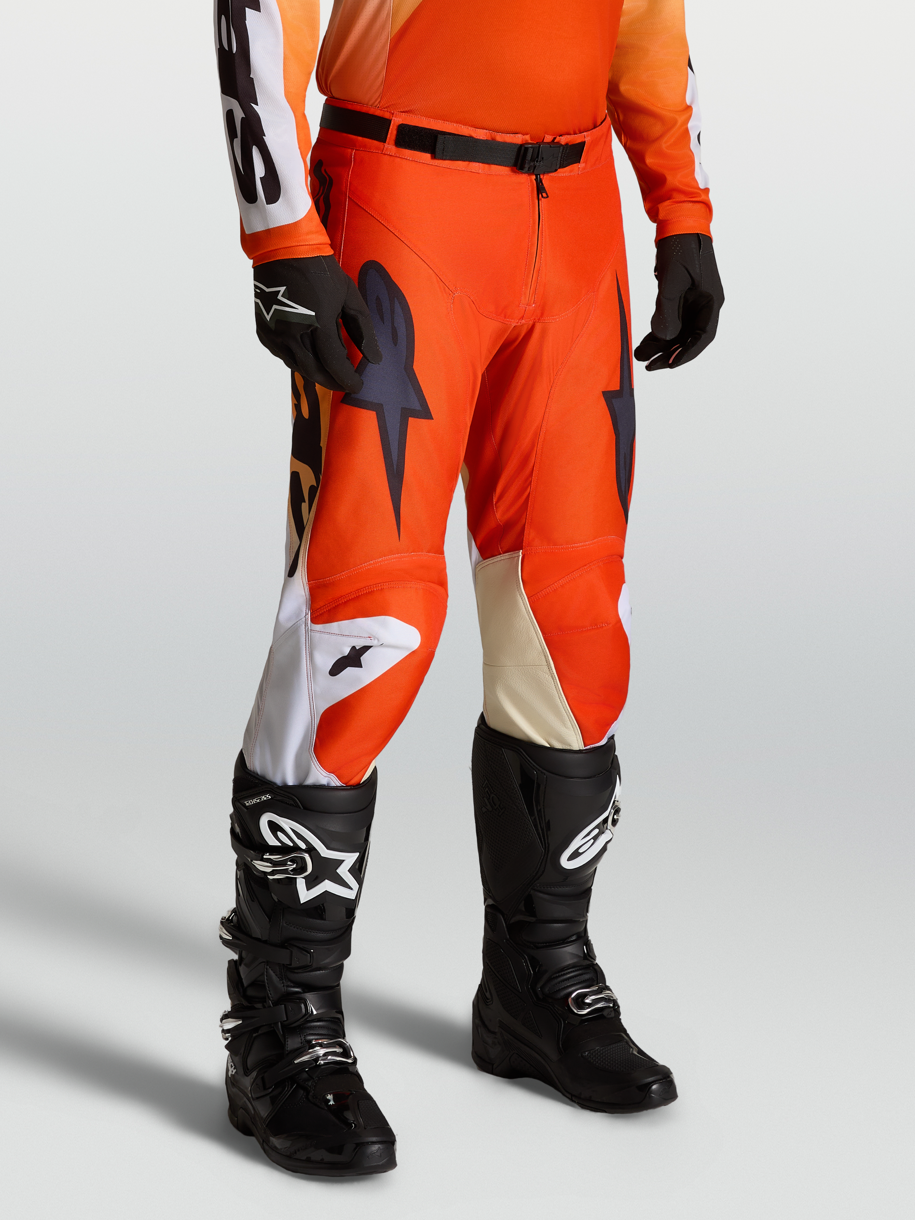 Spodnie Racer Amber, męskie spodnie motocrossowe, czerwone i czarne, na modelu z pasującą koszulką i butami Tech Series.